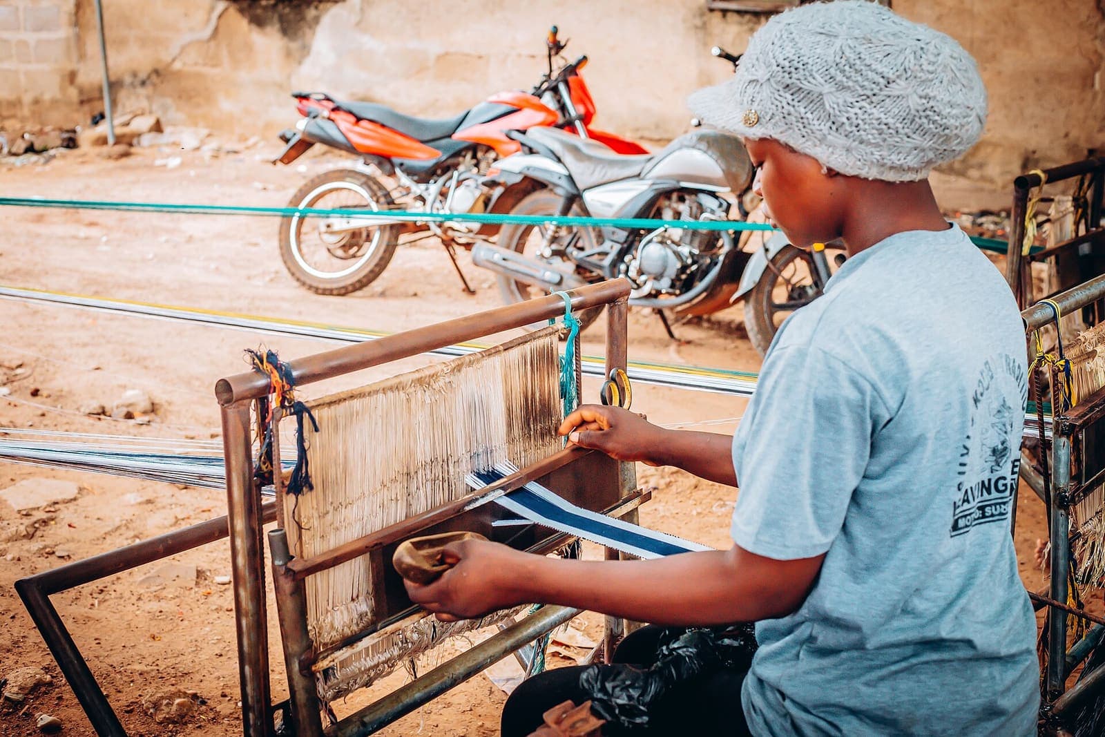 A weaver works at a loom producing kente cloth in northern Ghana.